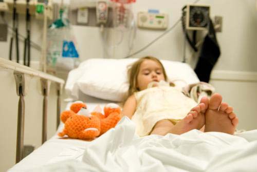 Niña en la cama del hospital.