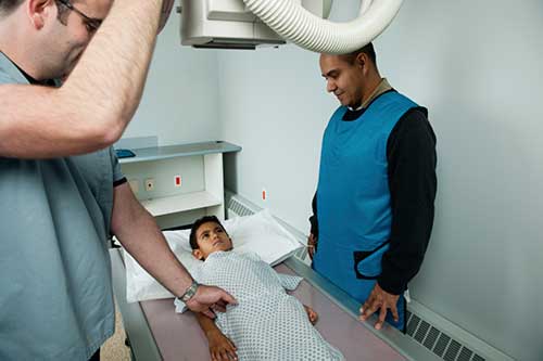 Radiologic technologist preparing patient for x-ray.